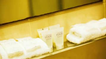 Una encimera de baño con toallas y productos para el cabello.