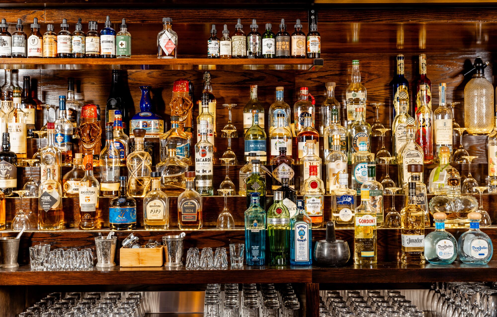 A bar with a variety of liquor bottles and glasses.