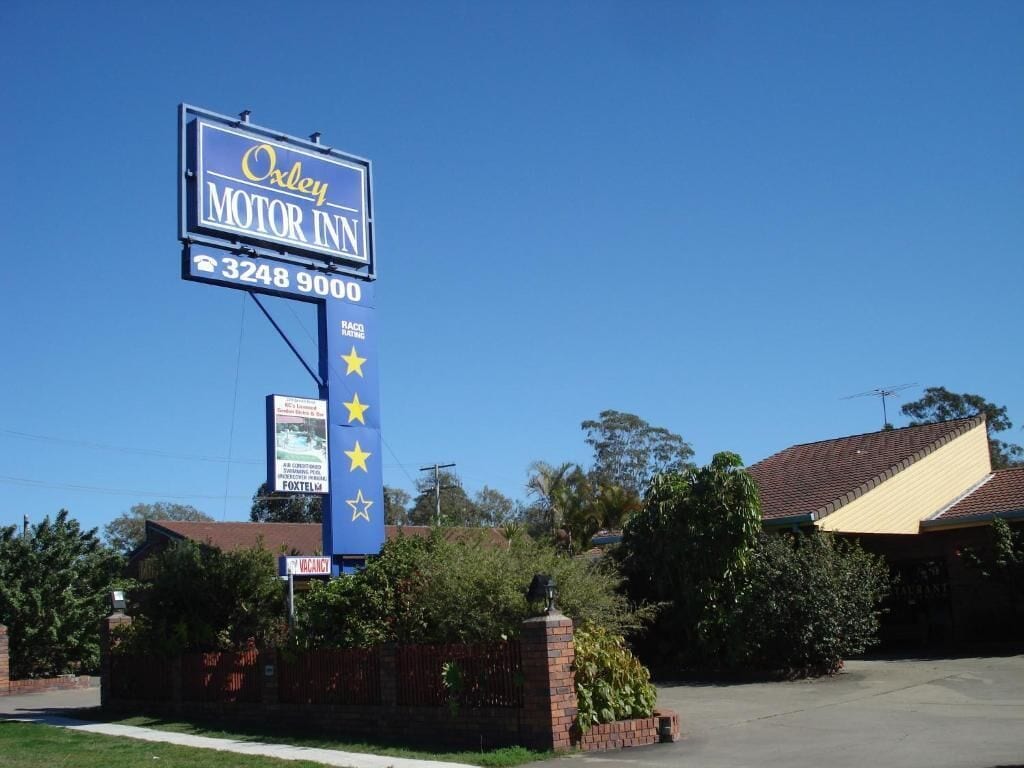 A motel sign with the name "Oxley Motor Inn" and a phone number.