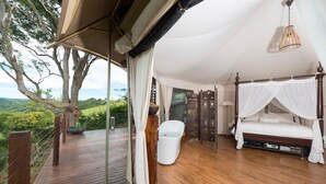 A bedroom with a canopy bed, a bathtub, and a view of the outdoors. - Clouds on Beechmont (Beechmont)