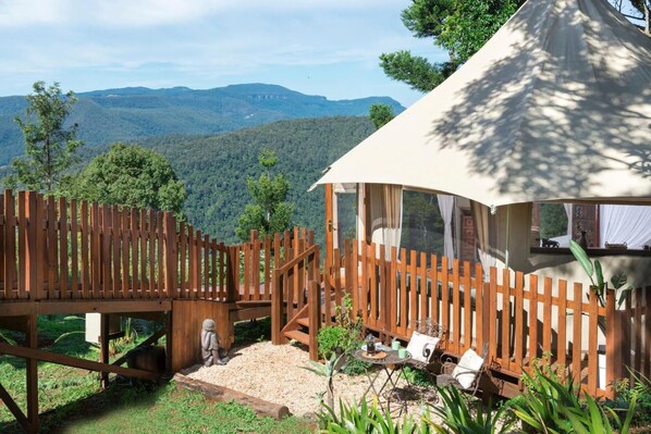 A wooden deck leading to a covered seating area with a view of mountains. - Clouds on Beechmont (Beechmont)
