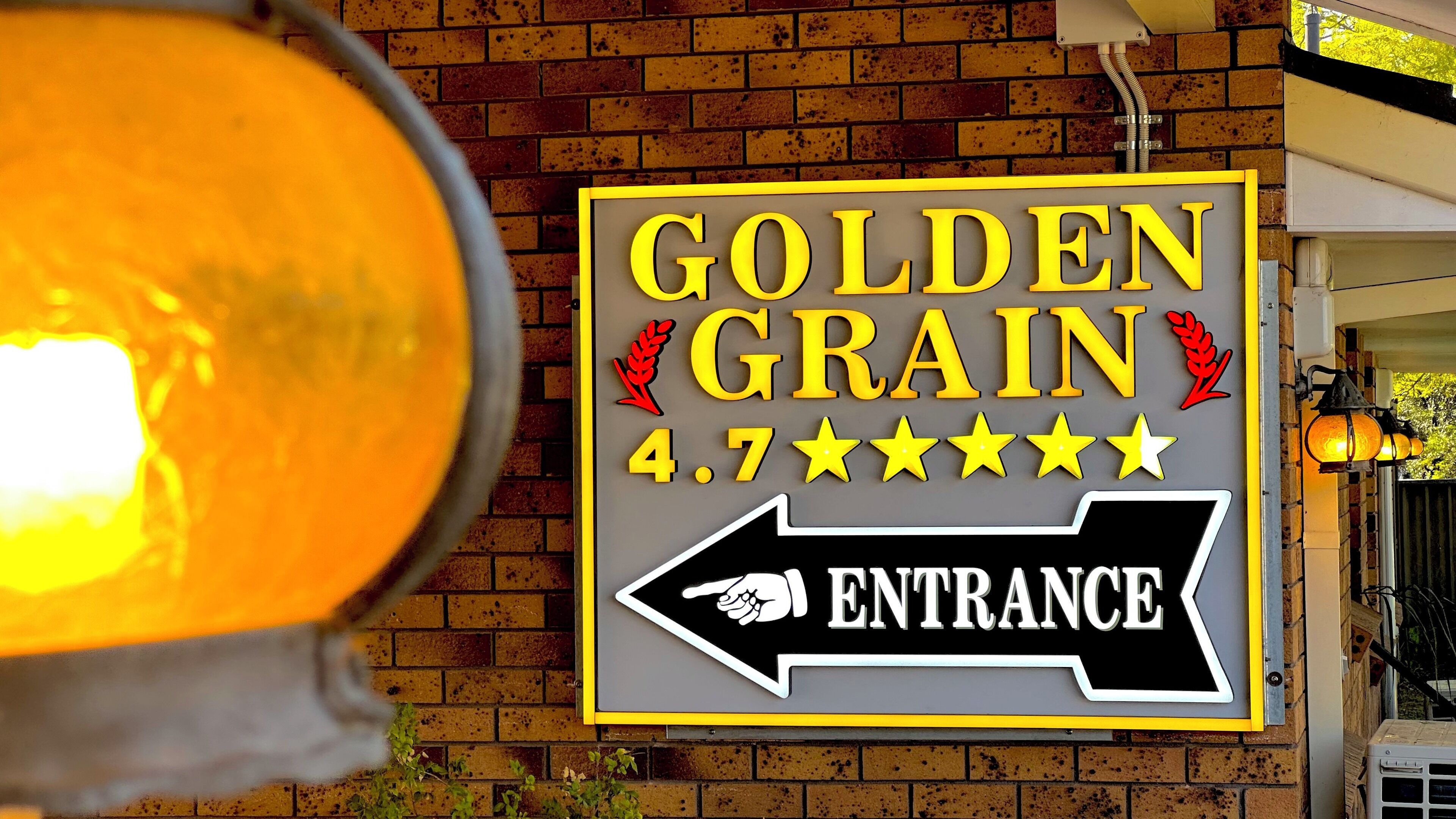 A sign for Golden Grain with a 4.7-star rating and an arrow pointing to the entrance.