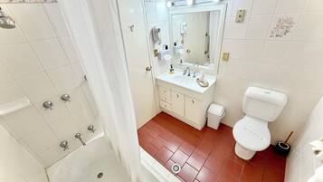 Un baño con ducha, inodoro, lavabo y tocador.