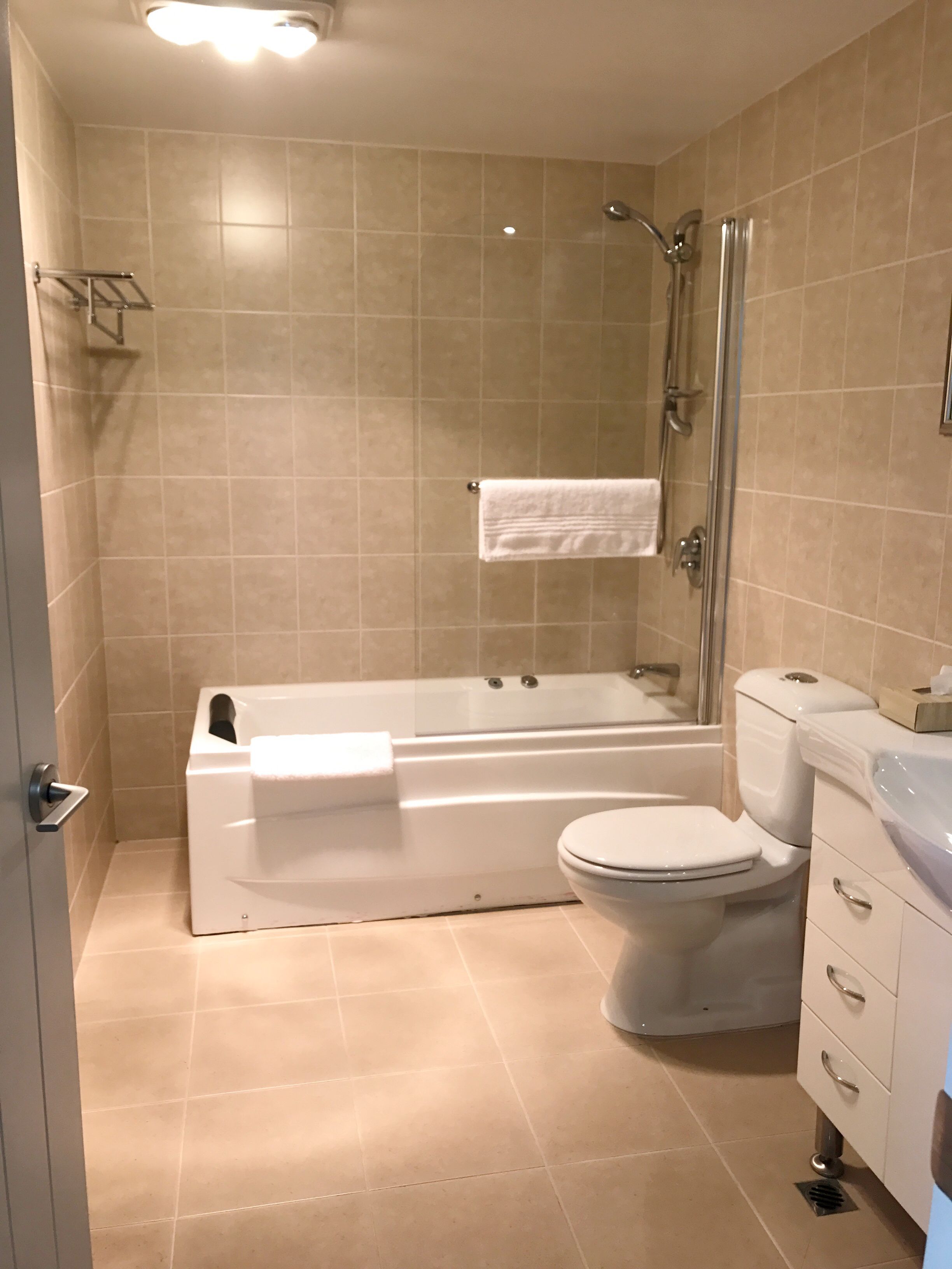 deluxe one bedroom apartment | bathroom | combined shower/bathtub, free toiletries, hair dryer, towels