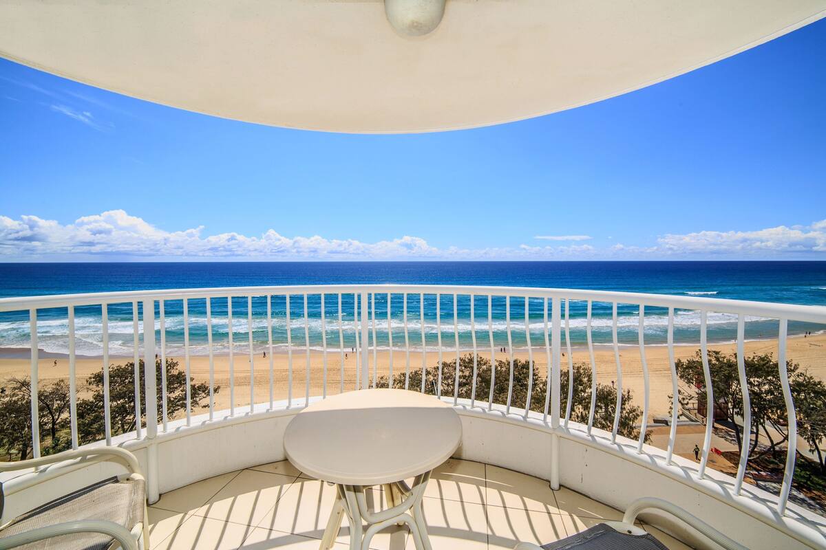 A balcony with a view of a beach and ocean.