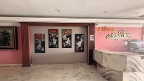 A reception area with a marble floor, a reception desk, and three framed artworks on the wall.