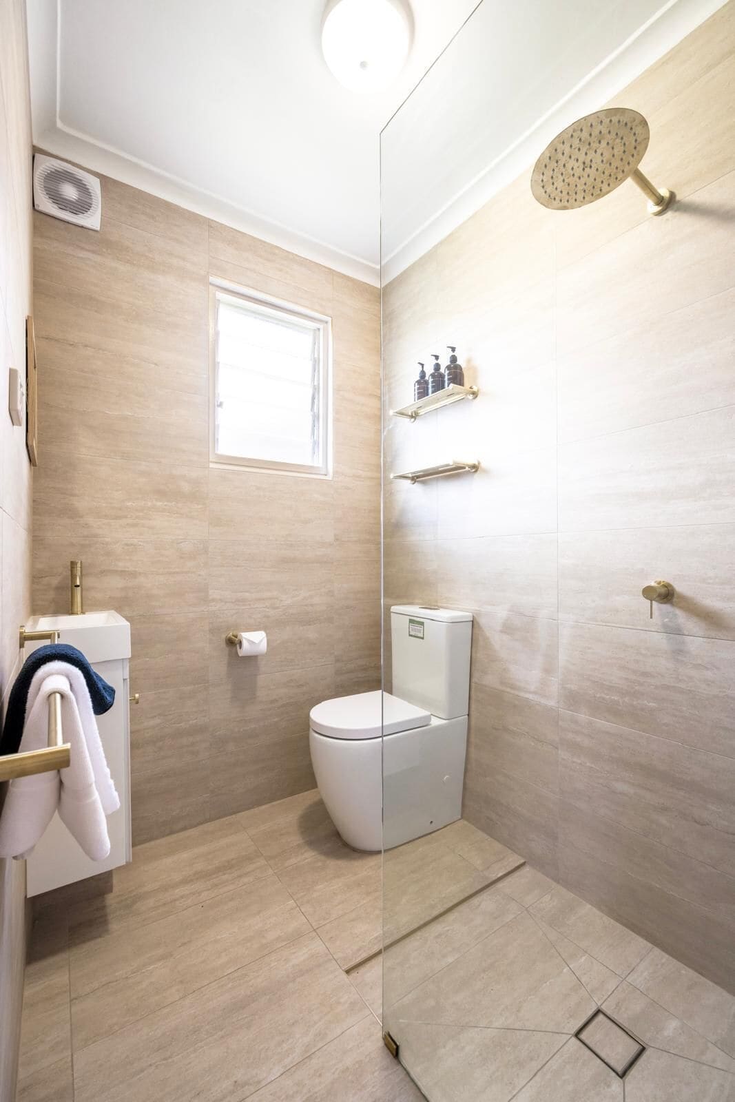 Un baño moderno con inodoro, ducha y ventana.