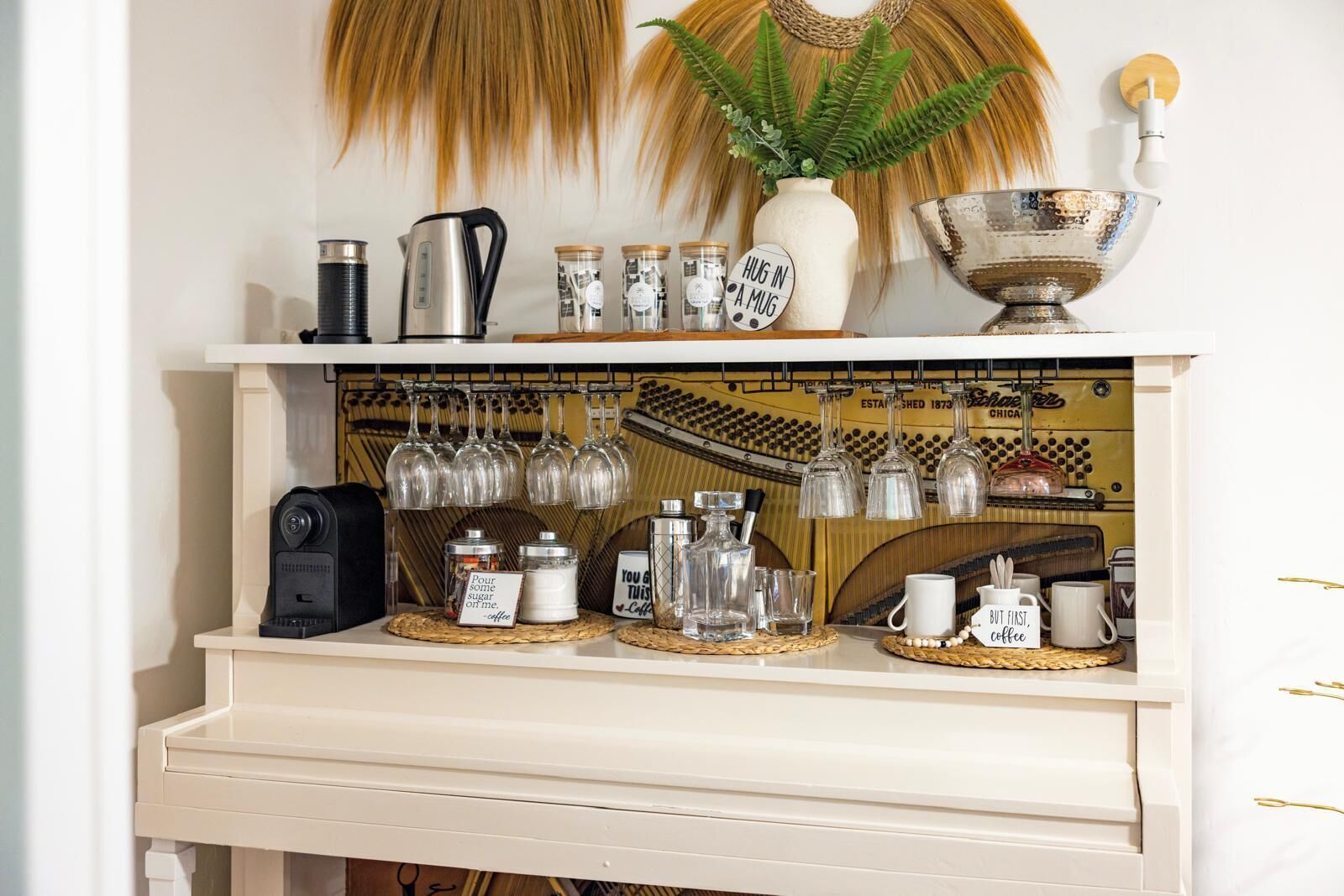 A kitchen counter with a coffee machine, a kettle, and various glassware.