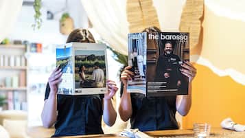 Two individuals holding a magazine with the title 'the barossa' and a logo that reads 'BAROSSA'.
