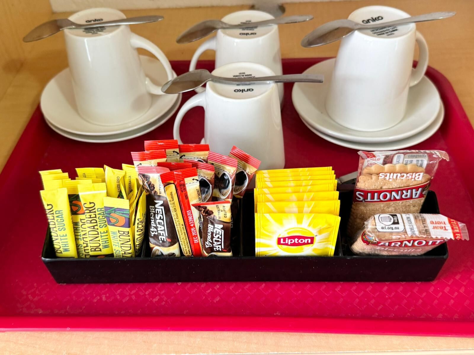 Ein Tablett mit Kaffeetassen und verschiedenen verpackten Snacks.