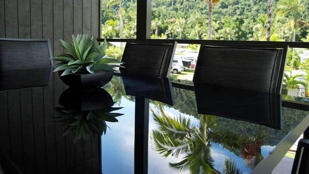 Une chambre moderne dotée d’une grande fenêtre donnant sur un paysage verdoyant et luxuriant.