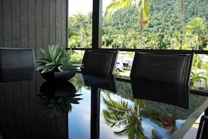 Quarto moderno com uma janela grande que oferece vista para uma paisagem verde exuberante.