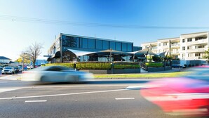 A modern building with a glass facade and a covered outdoor area. - Pippi's At The Point (Speers Point)