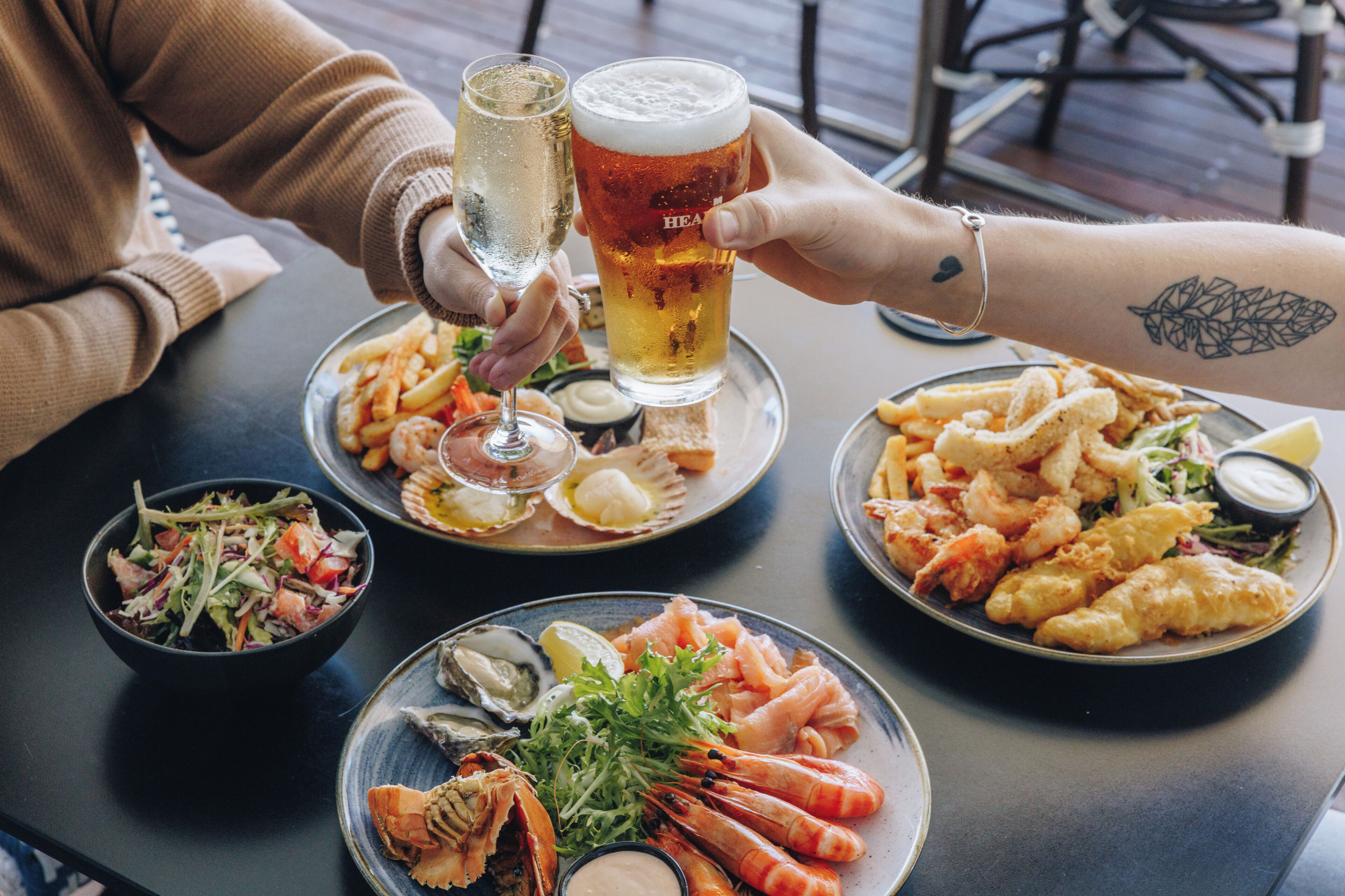 A table with seafood dishes, a salad, and drinks.