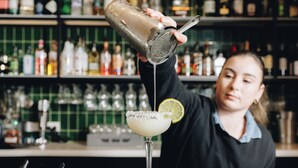 A bartender pouring a drink into a margarita glass with a lime garnish. - Pippi's At The Point (Speers Point)