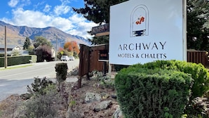 Letrero de Archway Motels & Chalets con montañas al fondo.
