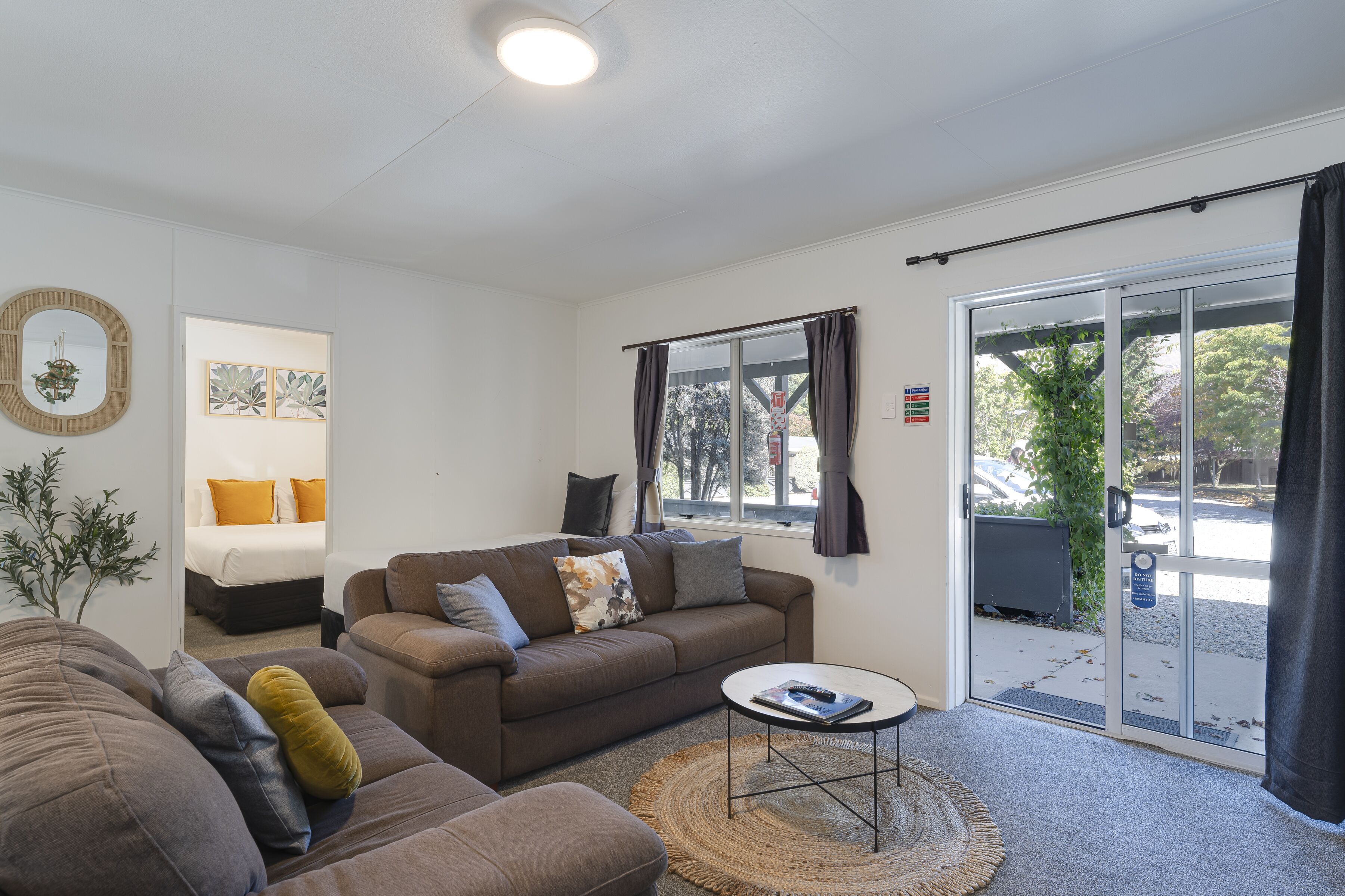 A modern living room with a sofa, a coffee table, and a large window.