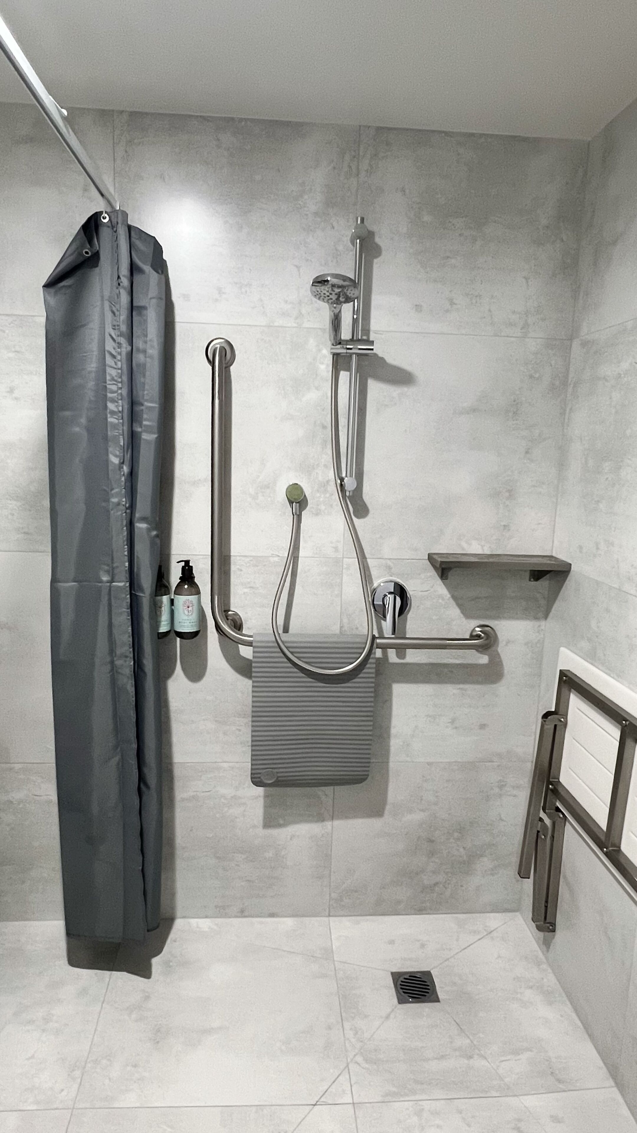 Un espace douche équipé d’un pommeau de douche, d’un pommeau de douche à main et d’un flexible de douche.