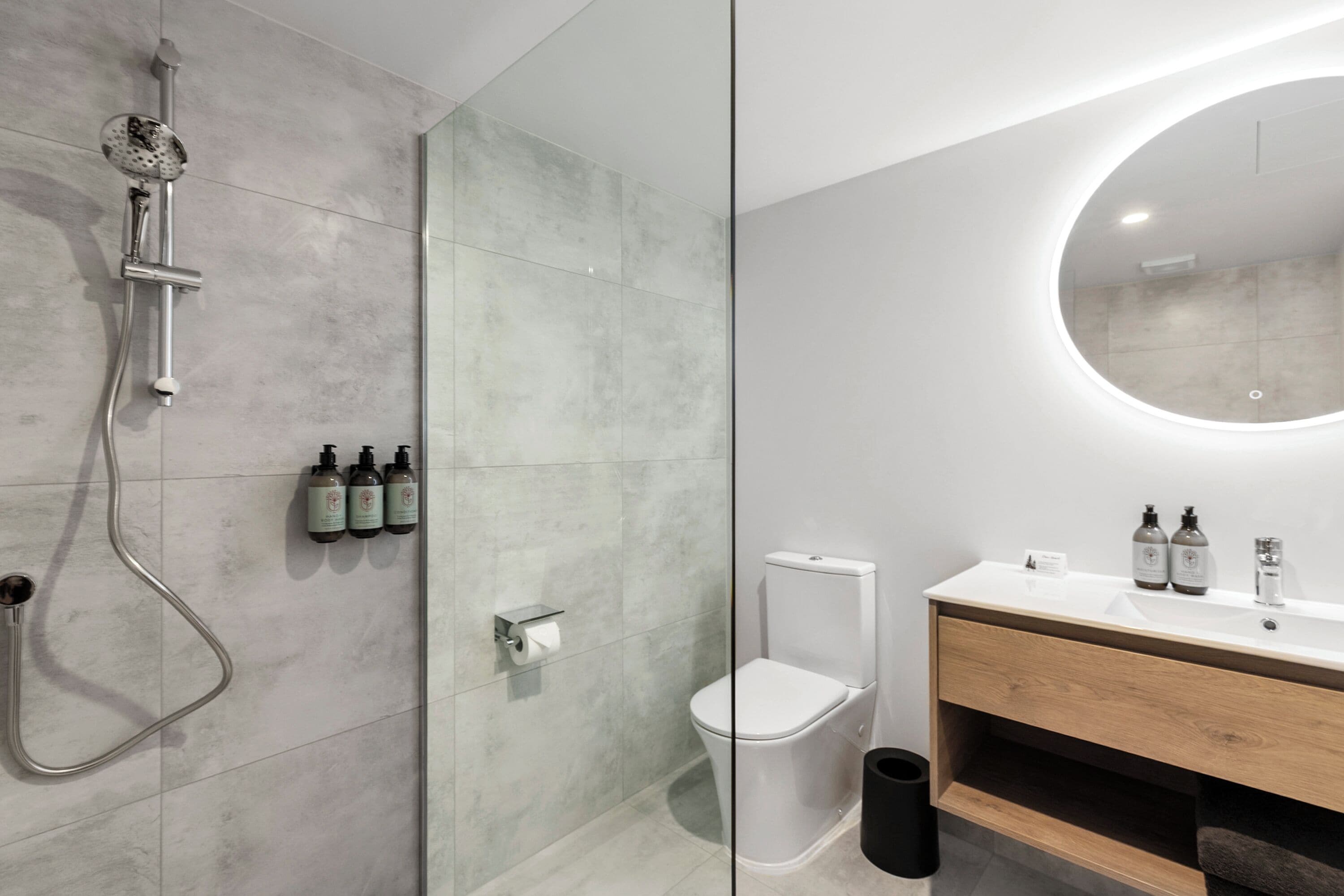 Une salle de bain moderne équipée d’une douche, de toilettes et d’un meuble-lavabo.