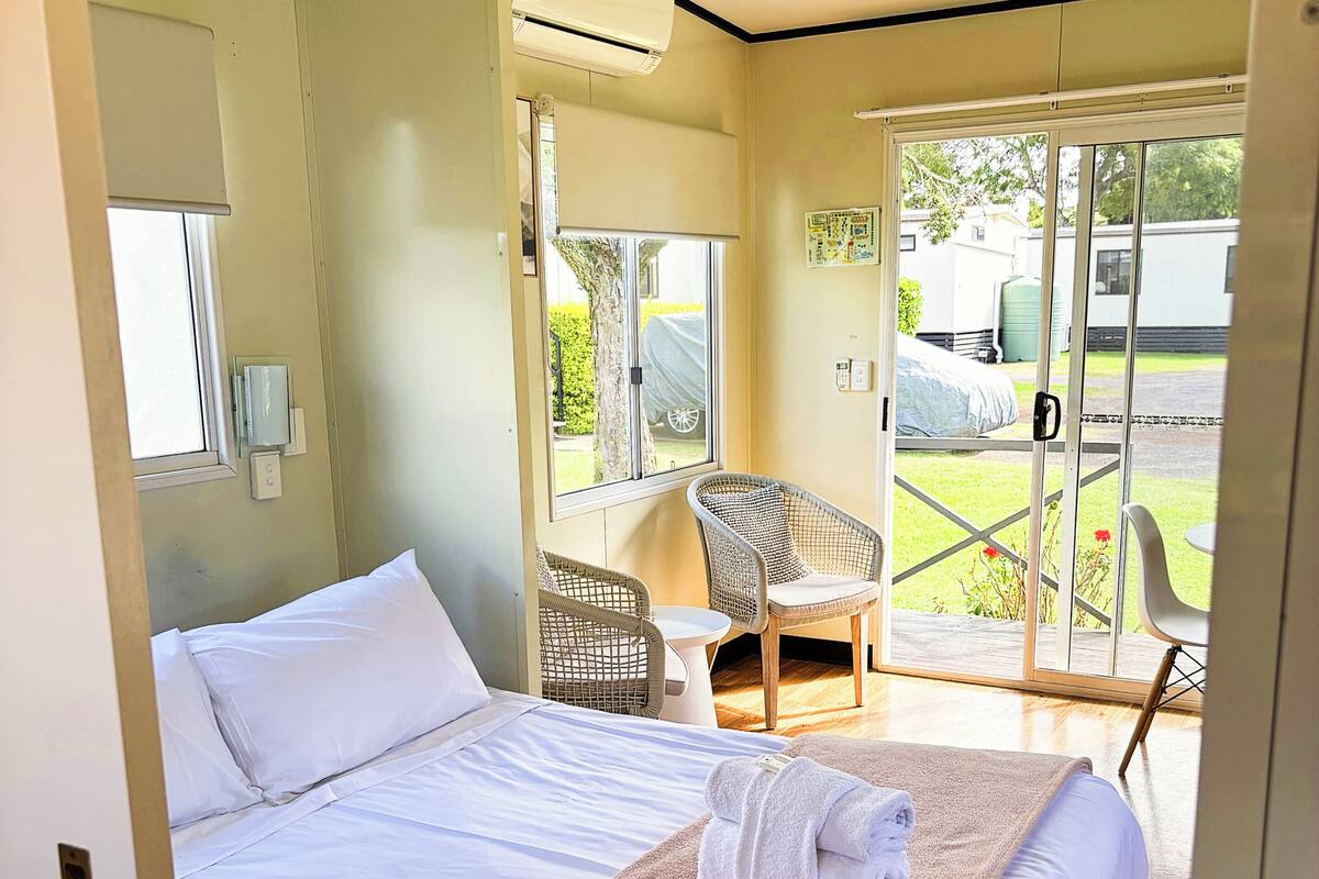Une chambre d’hôtel avec un lit, une fenêtre, une chaise et une table.