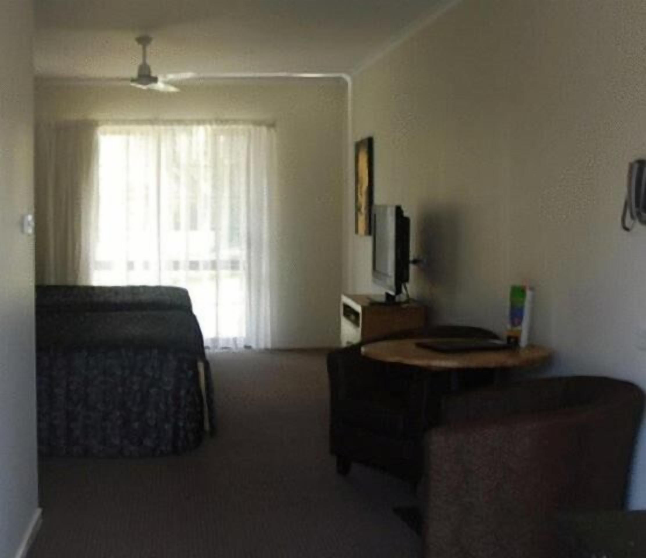 Une chambre d’hôtel équipée d’un lit, d’un bureau, d’une chaise et d’un téléviseur.
