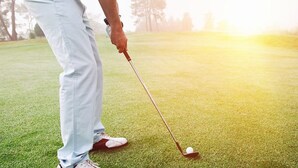 A person in light-colored pants and white shoes preparing to put a golf ball on a green. - Tocumwal Golf Resort (Tocumwal)