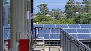 A covered outdoor area with chairs and a view of solar panels.