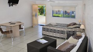 A room with a bed, a desk, a chair, and a coffee table. - Yamba Twin Pines Motel (Yamba)