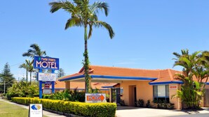A Twin Pines Motel with a clear sign, a palm tree, and a well-maintained lawn. - Yamba Twin Pines Motel (Yamba)