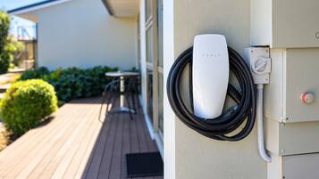 Una estación de carga para Tesla instalada en la fachada de un edificio.
