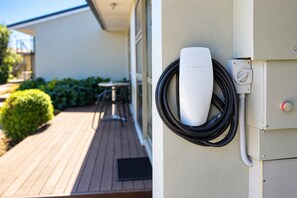 A Tesla charging station mounted on a building exterior. - Tower Junction Motor Lodge (Christchurch)