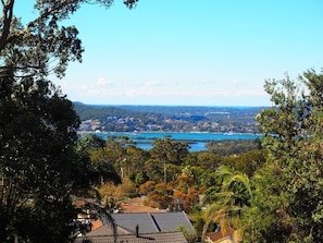 A coastal town with a view of the sea, surrounded by dense greenery and hills. - Bella Vista Motel (Kariong)