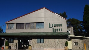 Um edifício de dois andares com uma placa que diz 'Linwood Lodge'.