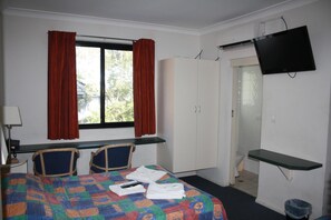 A hotel room with a bed, two chairs, a desk, a wardrobe, a TV, and a bathroom. - Linwood Lodge Motel (Greenwich)