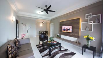 A modern living room with a sofa, coffee table, and a flat-screen TV mounted on the wall.