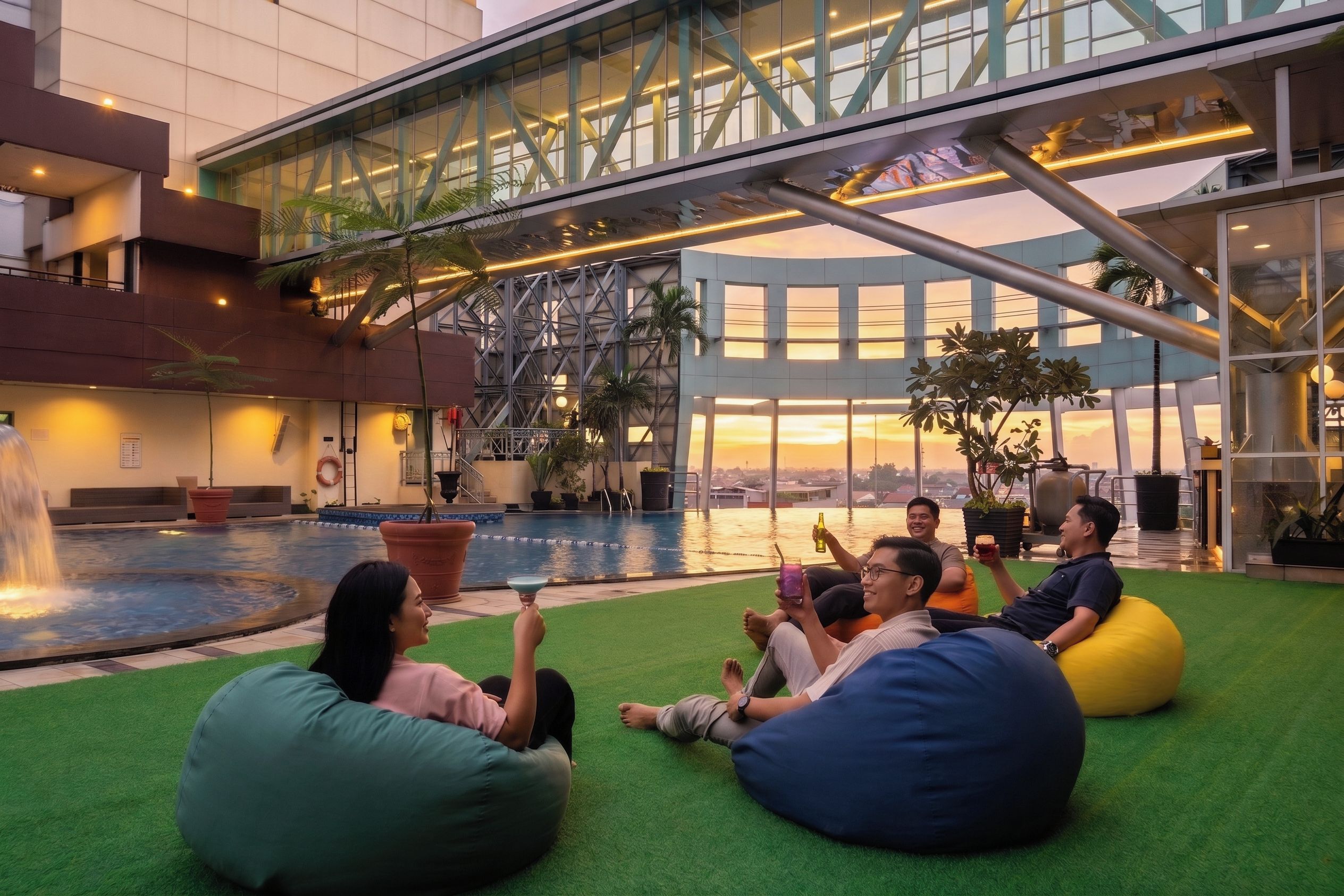 Un área de piscina en la azotea con asientos de césped artificial y vistas al horizonte de la ciudad.