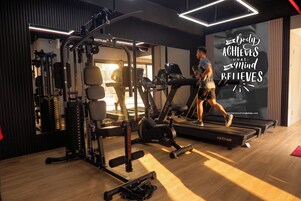 A gym with treadmills, weight machines, and a motivational poster.