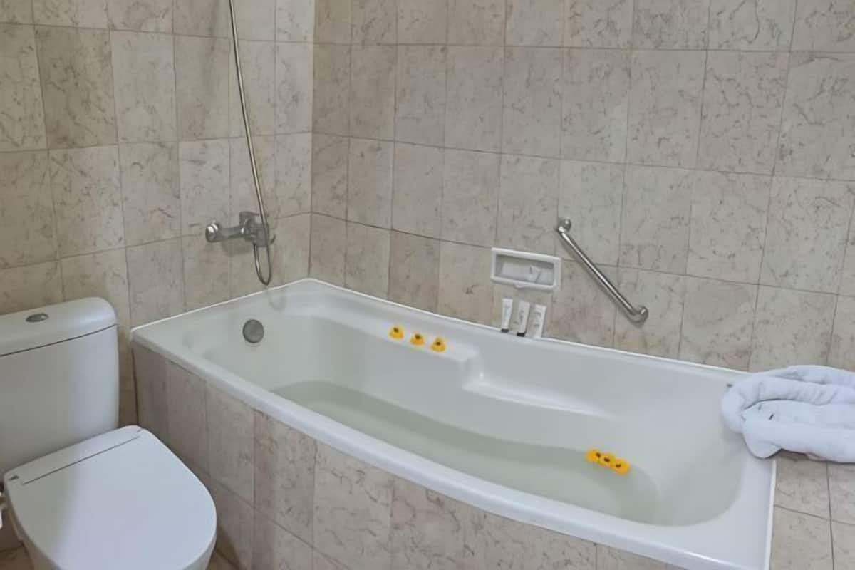 Ein Badezimmer mit Badewanne, Toilette und Handtuchhalter.