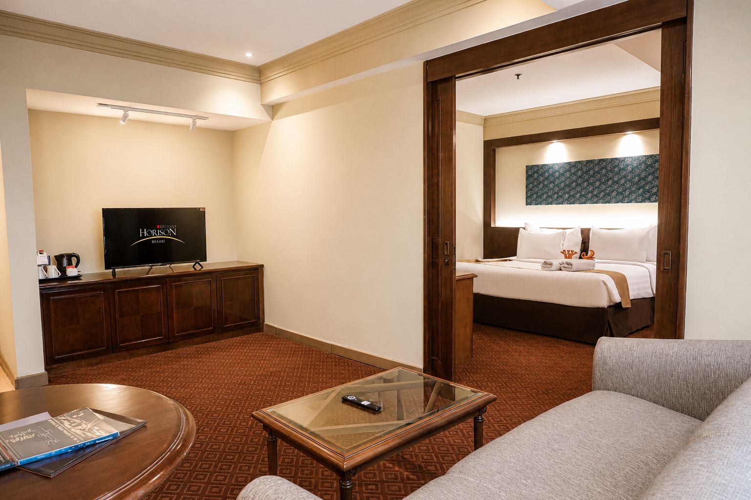 A hotel room with a bed, a television, a desk, and a sofa.
