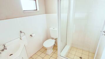 A bathroom with a toilet, a shower enclosure, and a bathtub.