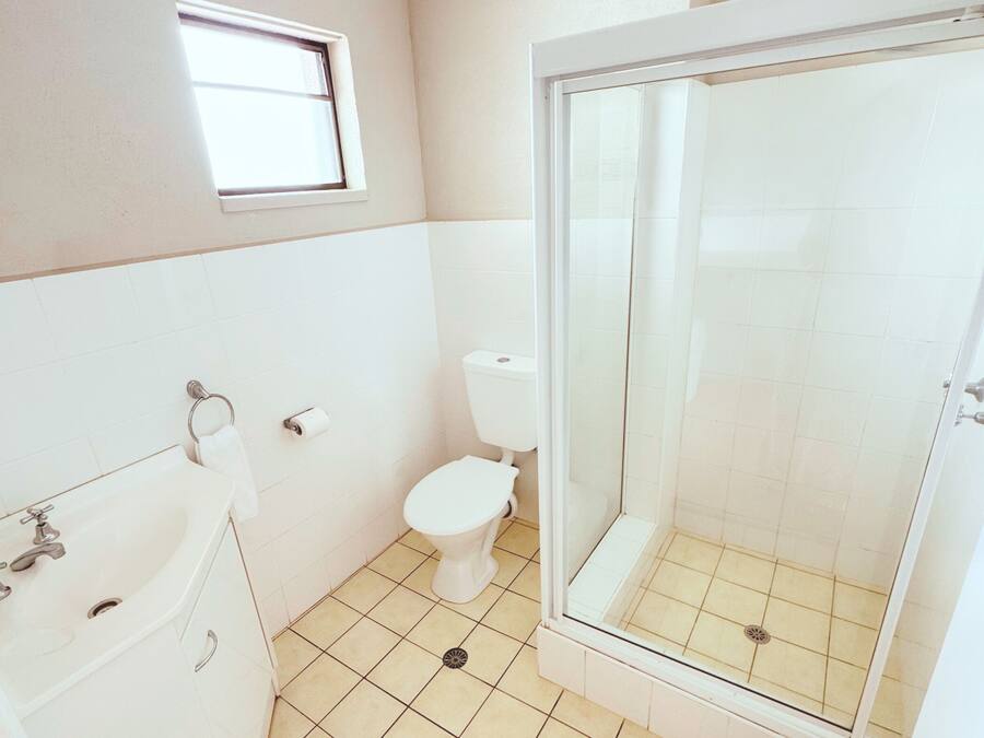 A bathroom with a toilet, a shower enclosure, and a bathtub.