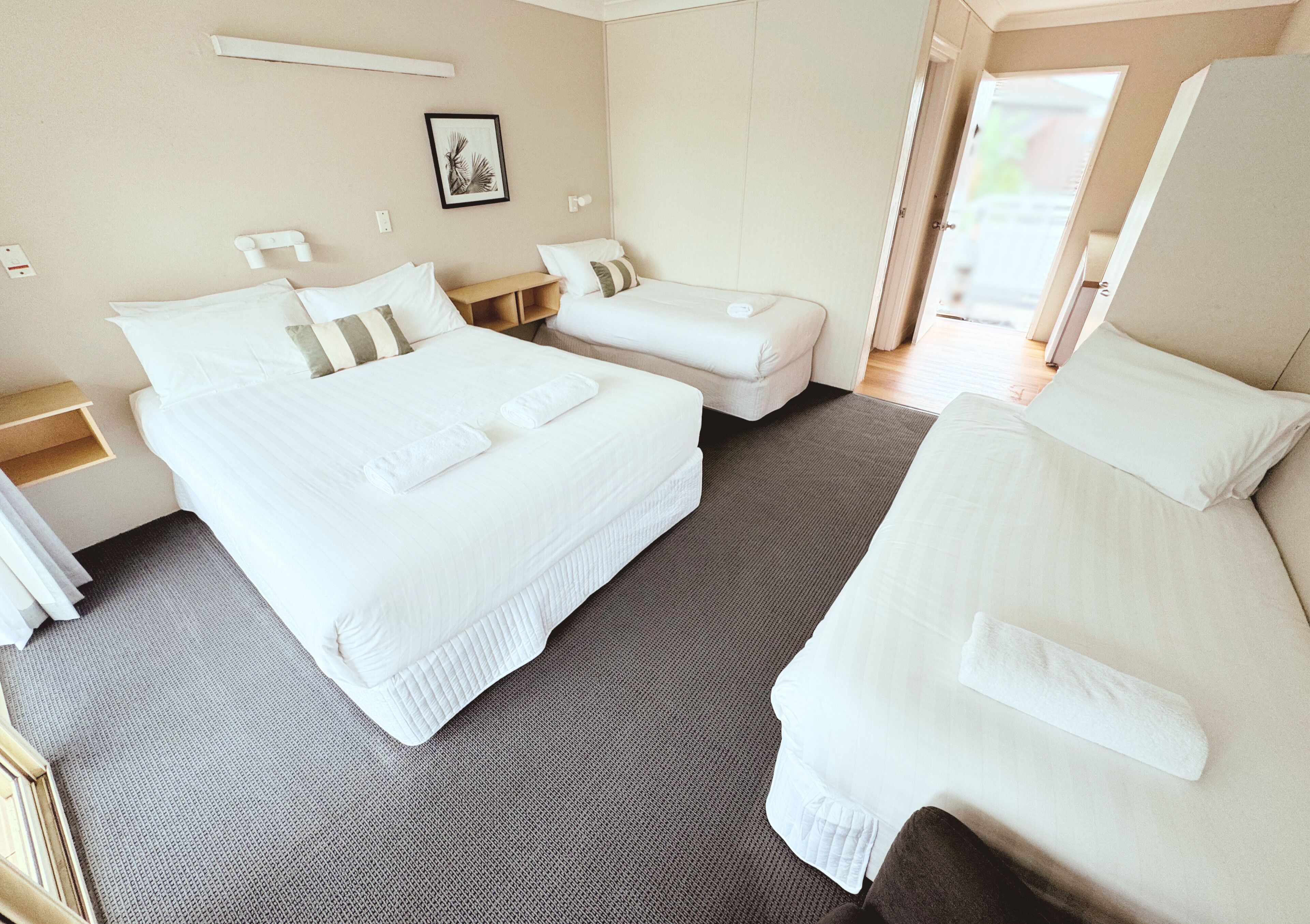 A hotel room with two beds, a desk, and a chair.