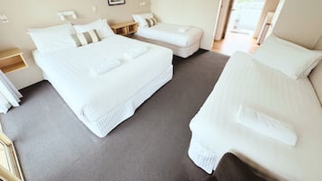 A hotel room with two beds, a desk, and a chair.