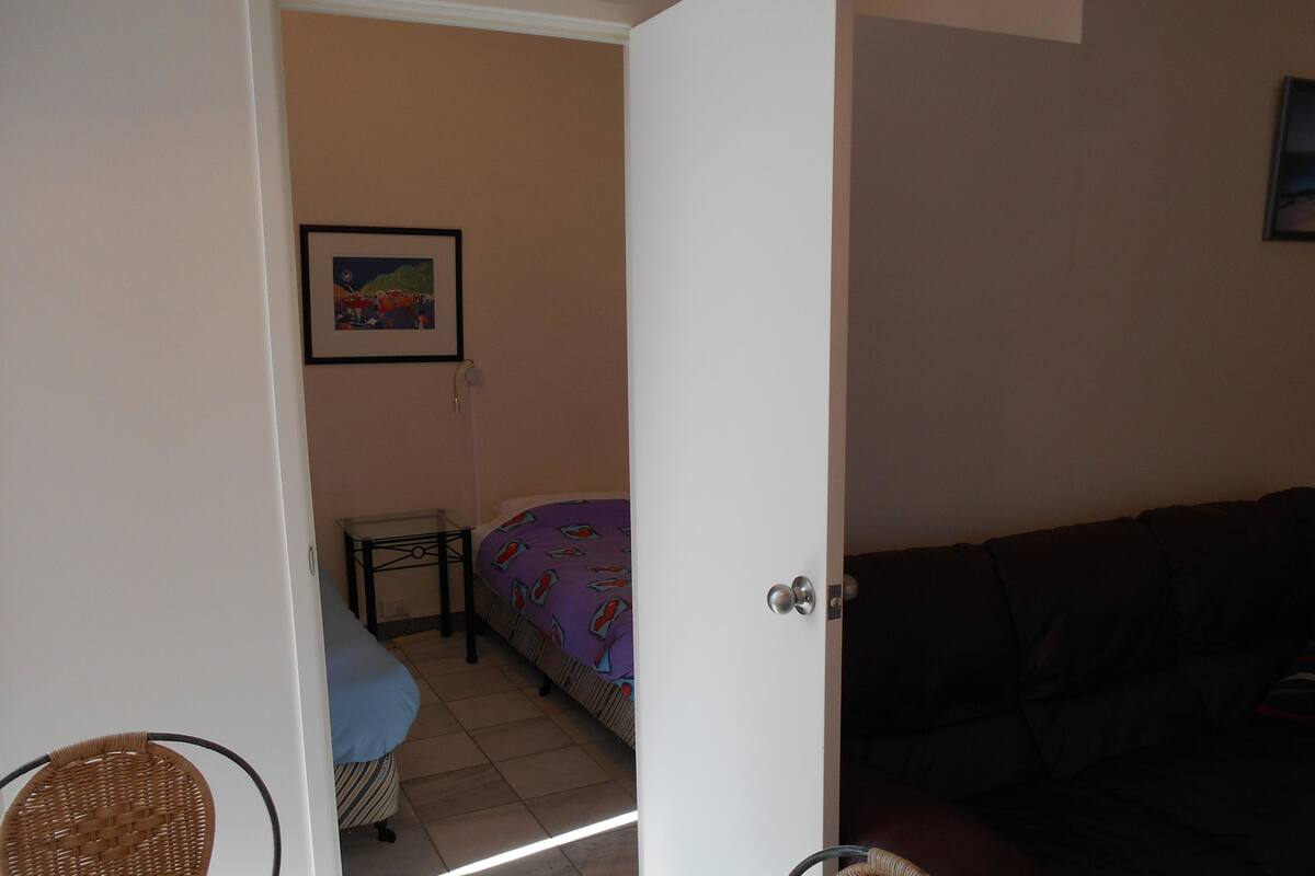 Une pièce comprenant un lit, une petite table, une chaise et un canapé.