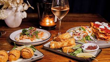 Una mesa con diferentes platos, una copa de vino y una vela.