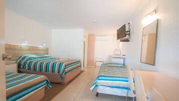 A hotel room with two beds, a desk, a chair, a TV, and a mirror.