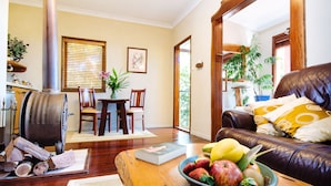 Una sala de estar acogedora con chimenea, comedor y sofá de cuero.
