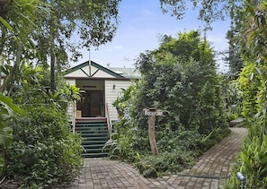 Welcome to our serene retreat, surrounded by lush greenery and a charming entrance.