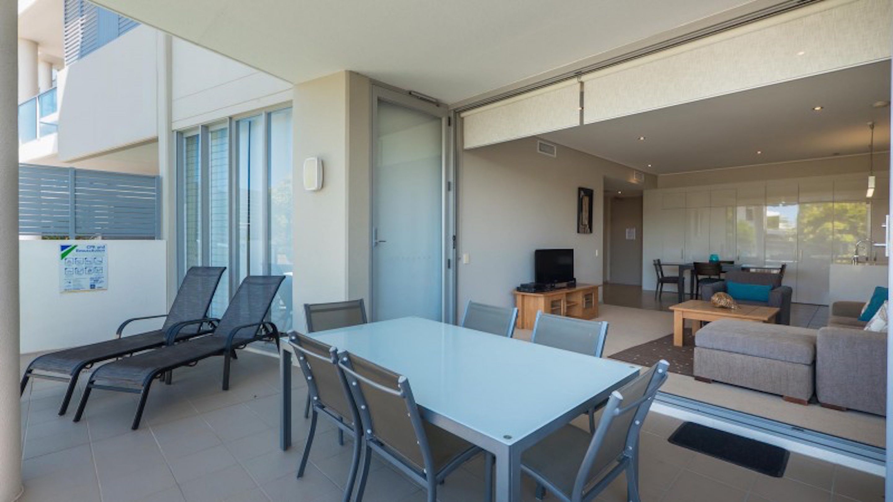 A modern apartment with a dining area, a living room, and a balcony.