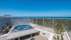 A rooftop terrace with a hot tub, a pergola, and a view of the ocean. - White Shells Luxury Apartments (Marcoola)